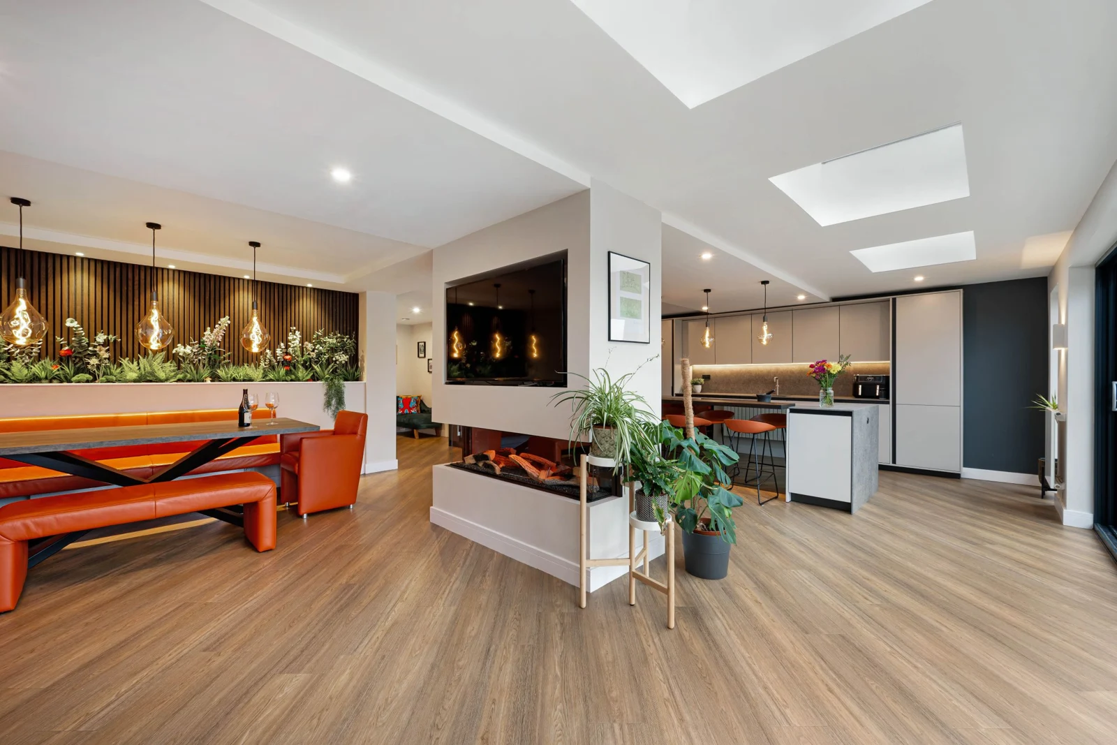 Open-plan home interior with kitchen, dining area and central fireplace
